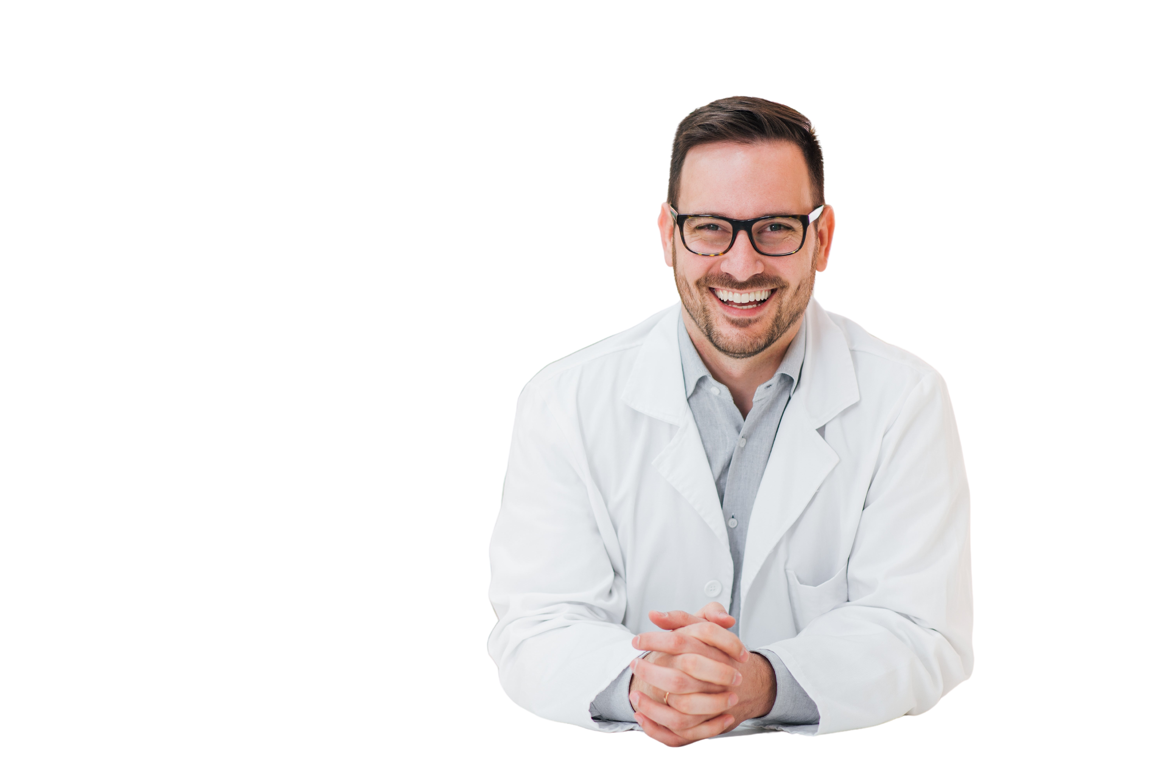 Portrait of a cheerful young pharmacist leaning on a counter at drugstore, looking at camera.