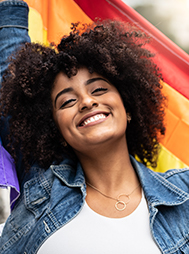 smiling African American woman waving the pride flag