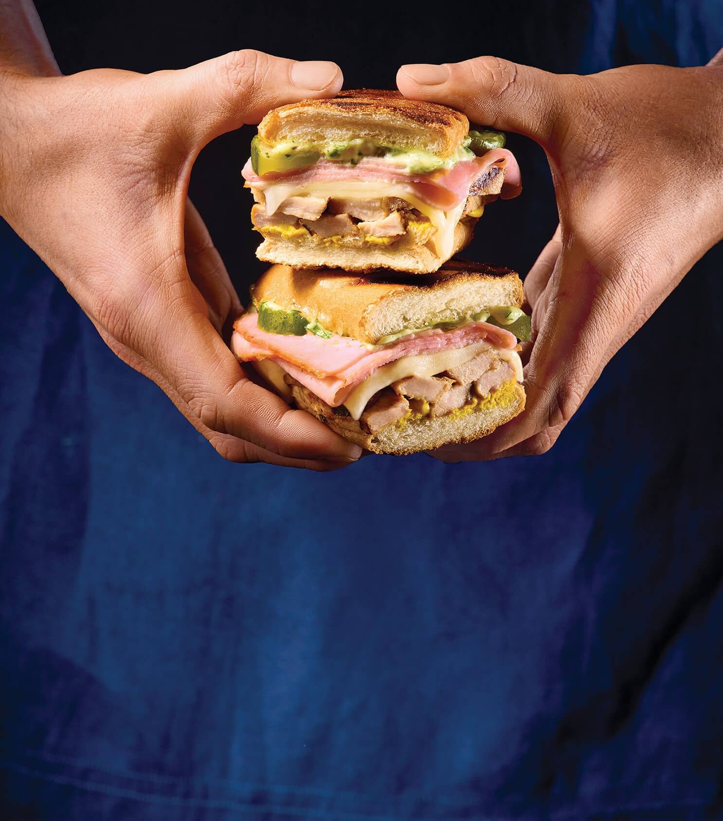 A man holding Grilled Mojo Cuban Sandwiches.