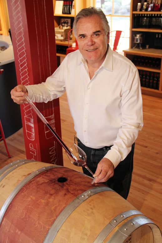 Sampling wine from a barrel