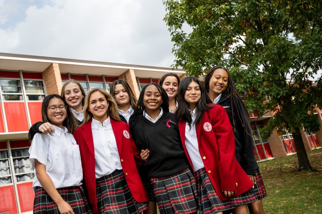 Attractive aged businesswoman, teacher or mentor coach speaking to young people, senior woman in glasses teaching audience at training seminar, female business leader speaker talking at meeting