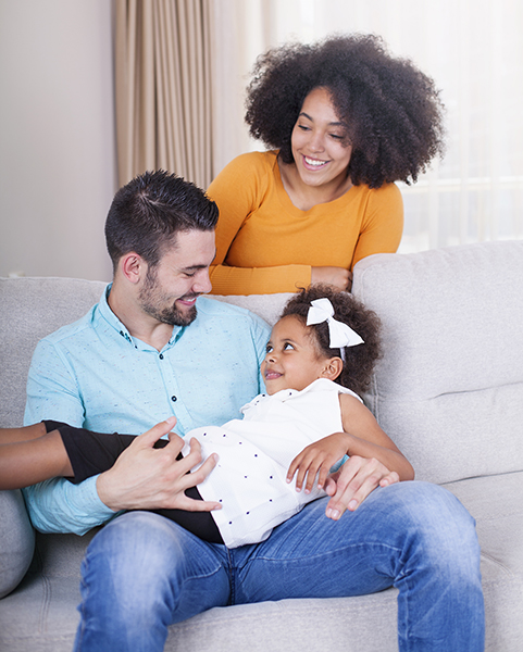 A young multi racial couple playing with their daughter.