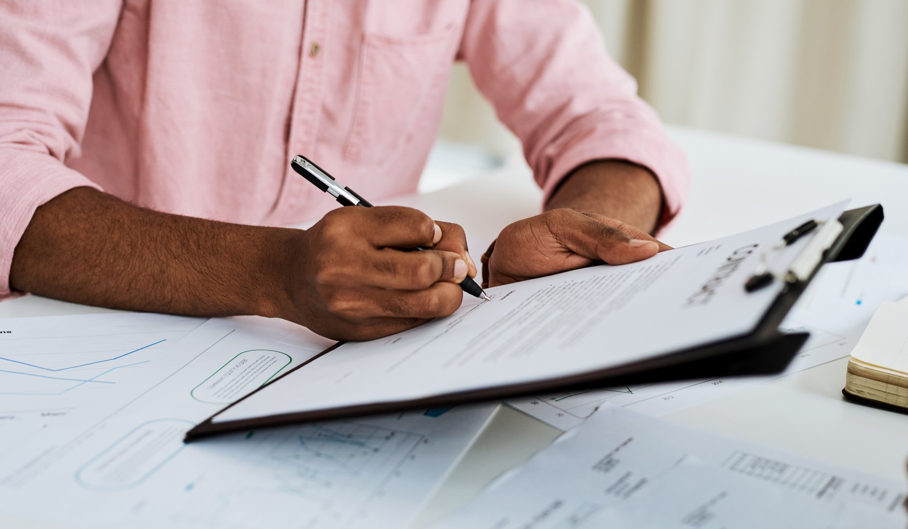 Man signing documents on clipboard