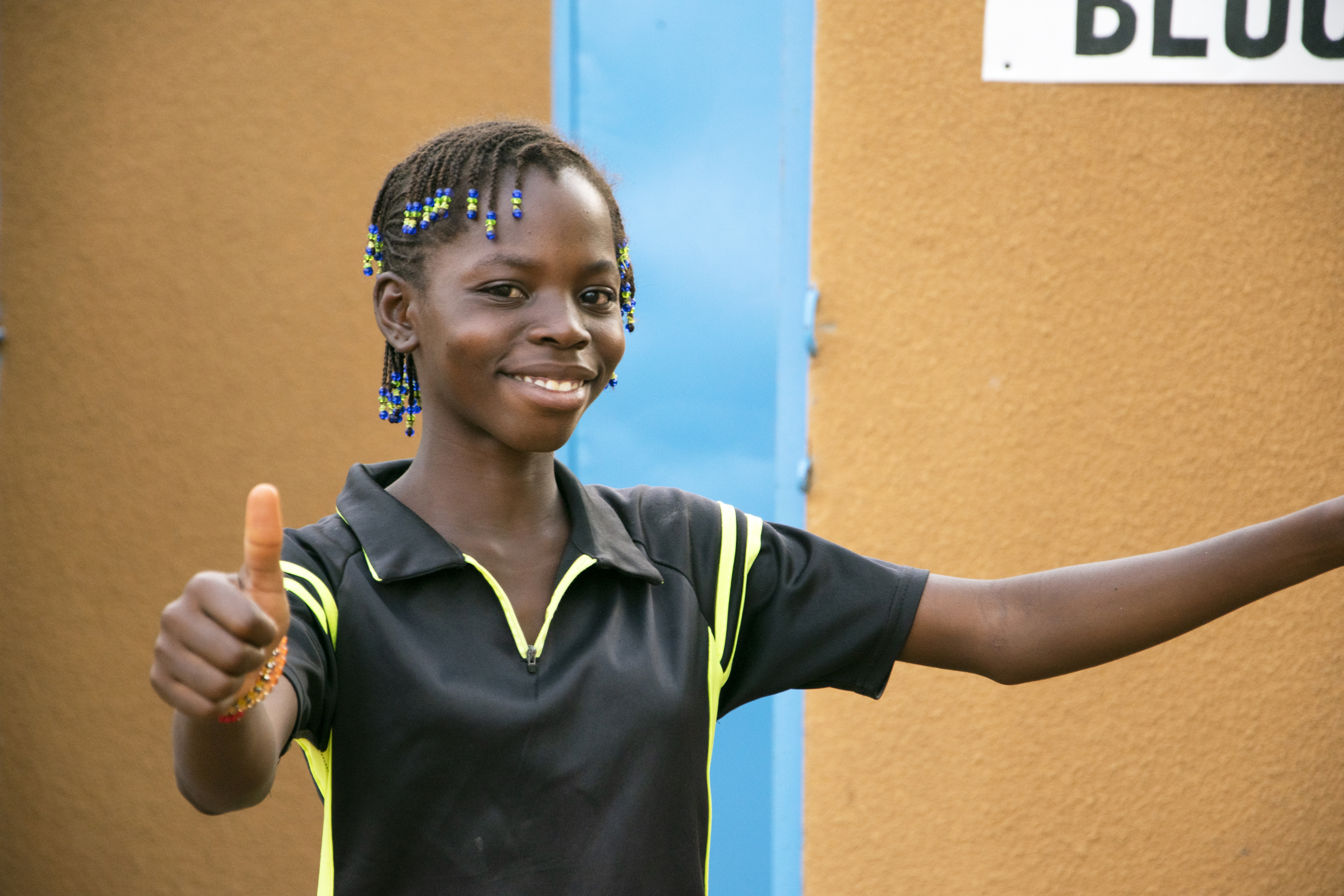 Awa, 13, gives a thumbs up to the new toilet block at her school 