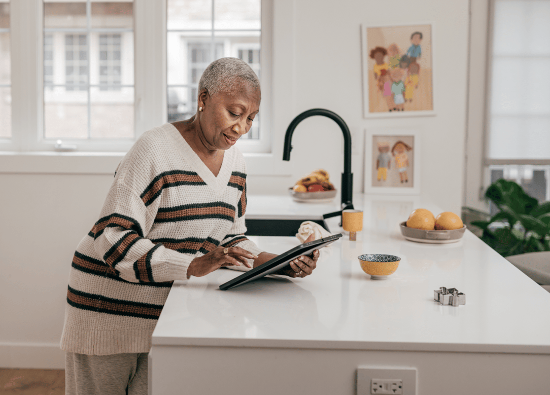 Senior women using smart home app in her kitchen