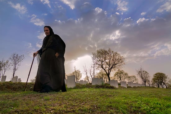 older woman at a graveyard