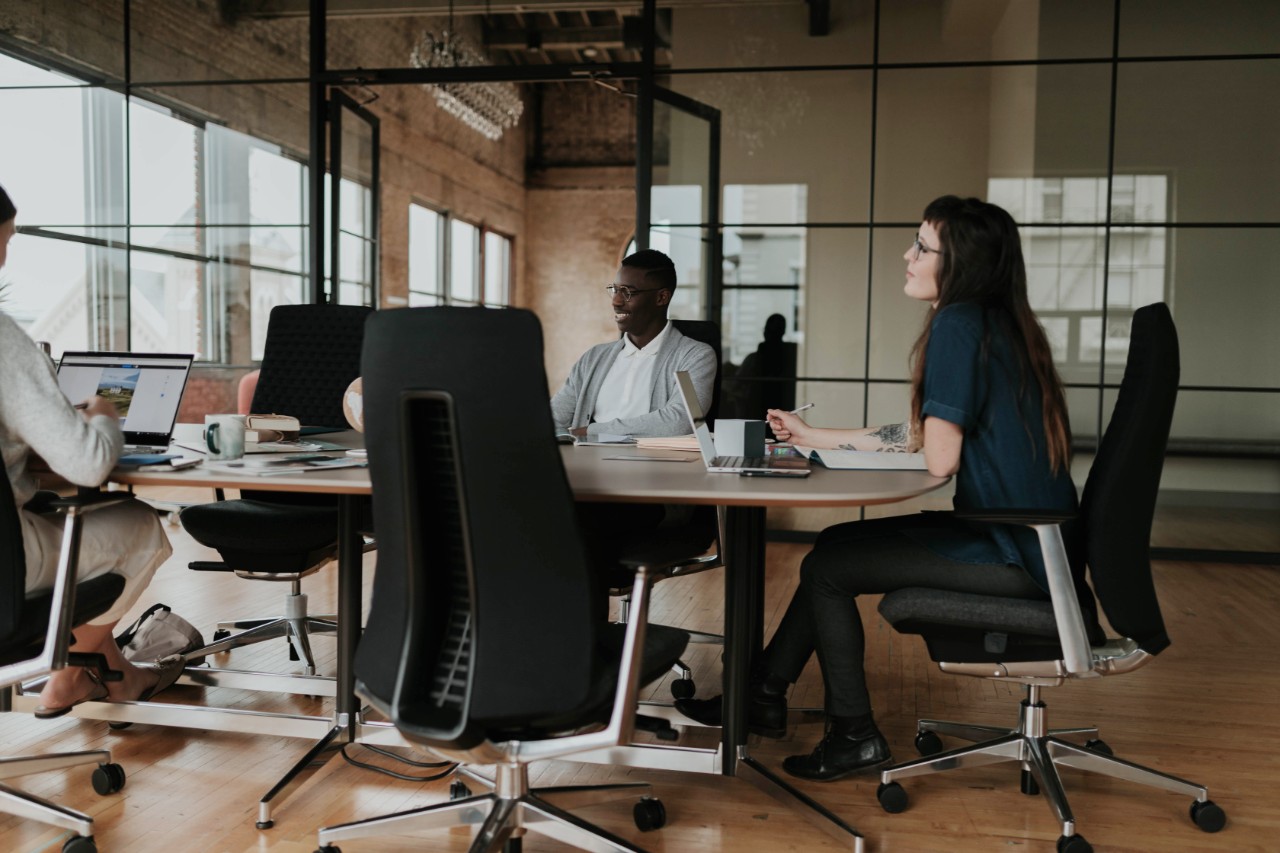 Happy young interracial couple shake hand of bank manager broker buy insurance services take mortgage loan, mixed ethnicity customers handshake agent make agreement financial business deal at meeting