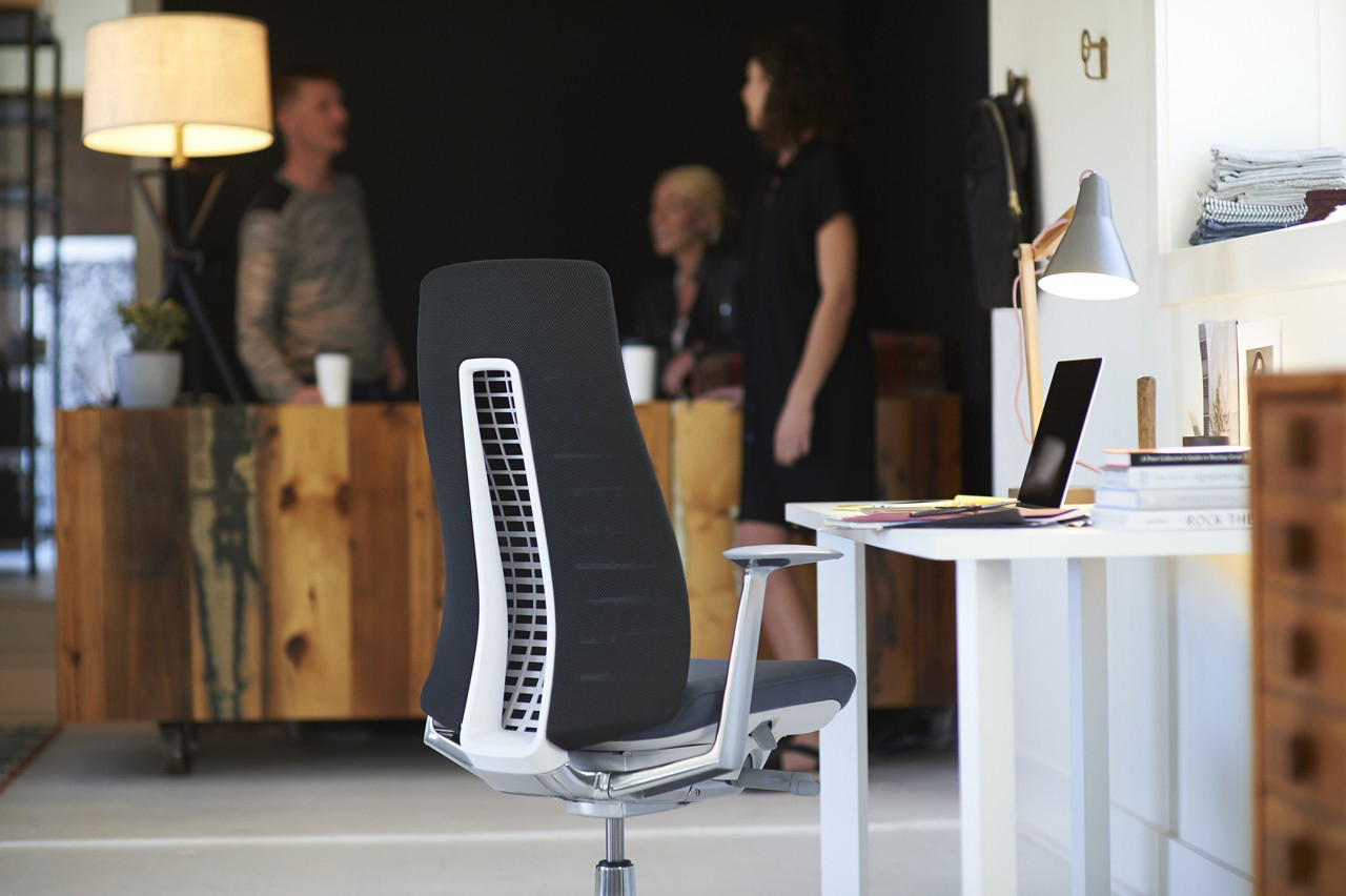 Female manager stands addressing team at board meeting