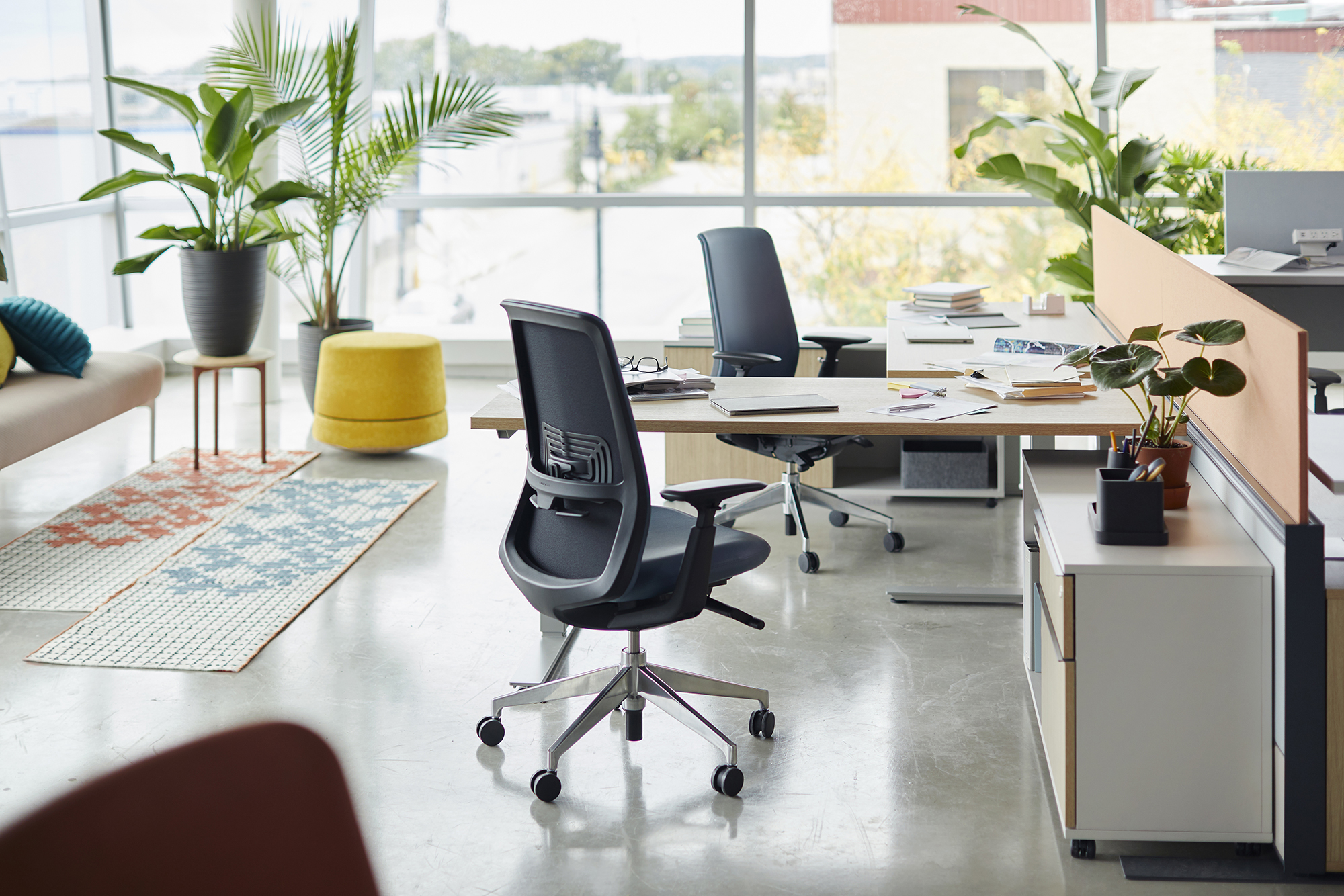 Attractive aged businesswoman, teacher or mentor coach speaking to young people, senior woman in glasses teaching audience at training seminar, female business leader speaker talking at meeting